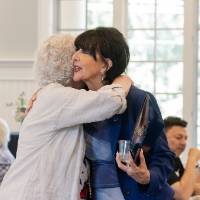 Marcia Haas giving hug to President Mantella